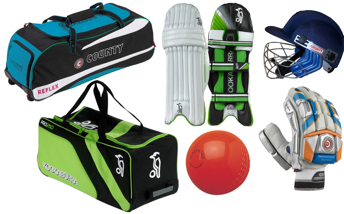 A collection of cricket gear including two kit bags, batting pads, a helmet, gloves, and a red cricket ball, all displayed on a white background.