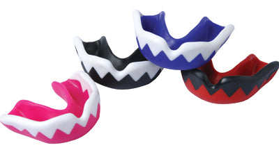 Four colorful mouthguards are arranged on a white background. Each has a zigzag pattern along the front edge; the colors are pink, black, blue, and red, all with white or black accents.