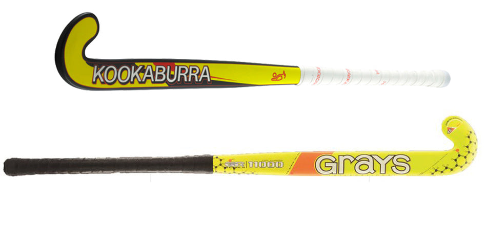 Two yellow and black field hockey sticks, one labeled KOOKABURRA with a white grip, and the other labeled GRAYS with a black grip, displayed against a white background.