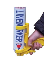 A hand holding a yellow applicator with a canister labeled LINE MARKER used for marking lines on surfaces.