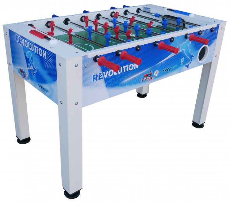 A white and blue foosball table with red and blue player figures, labeled REVOLUTION on the sides. The table has black feet and a soccer-themed design.