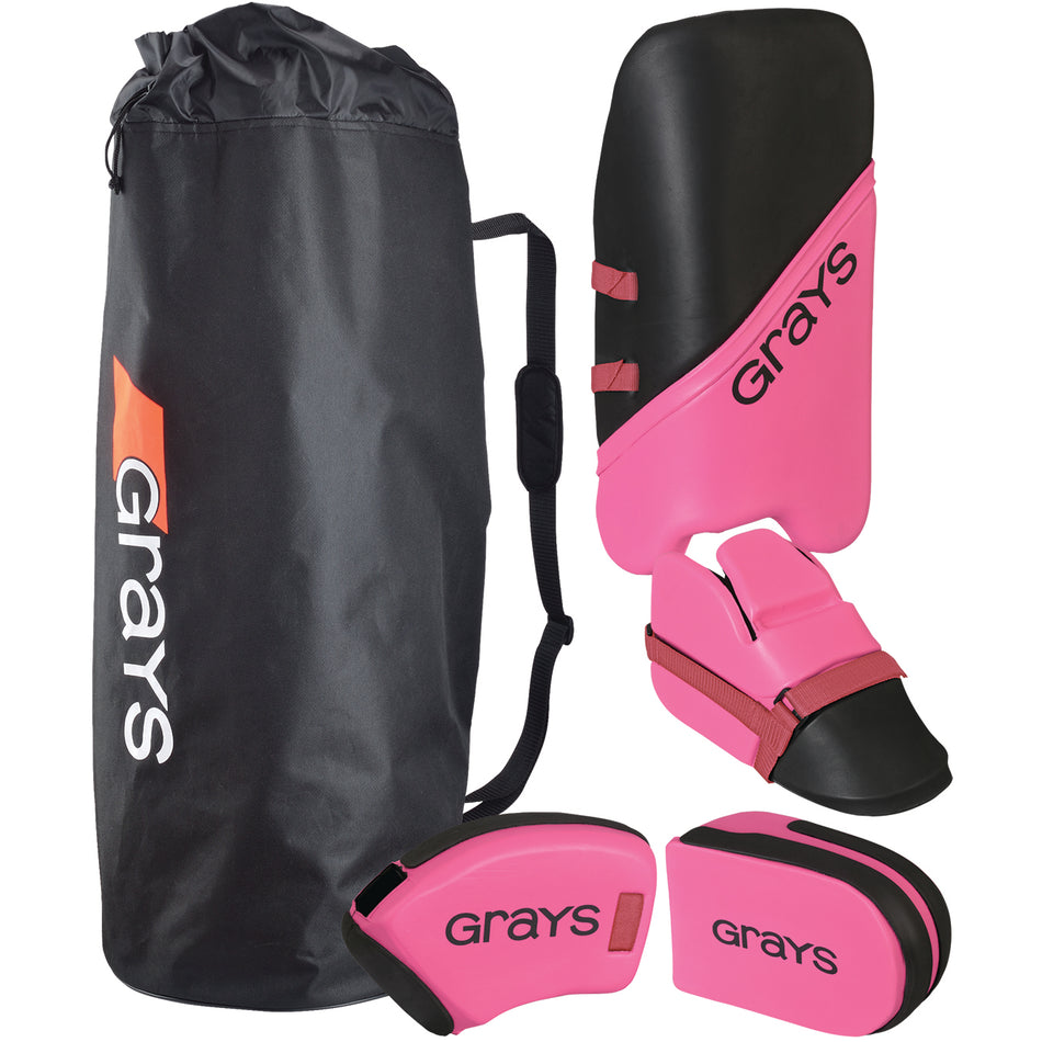 A black Grays-branded sports bag next to pink and black field hockey goalie equipment, including leg guards, a kicker, and hand protectors.
