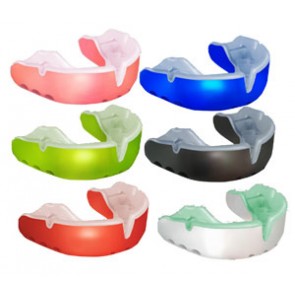Six colorful mouthguards are arranged in two rows. The colors are pink, blue, green, black, red, and white, each with a transparent section at the top for teeth protection.