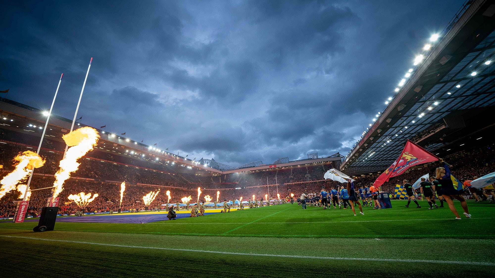 Four short-sleeve rugby shirts: red and black stripes, blue and black stripes, white and black stripes, and yellow and black stripes, each with a logo on the chest.