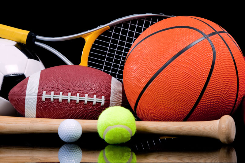 A basketball, soccer ball, football, tennis ball, two golf balls, a baseball bat, and a tennis racket are grouped together against a black background.