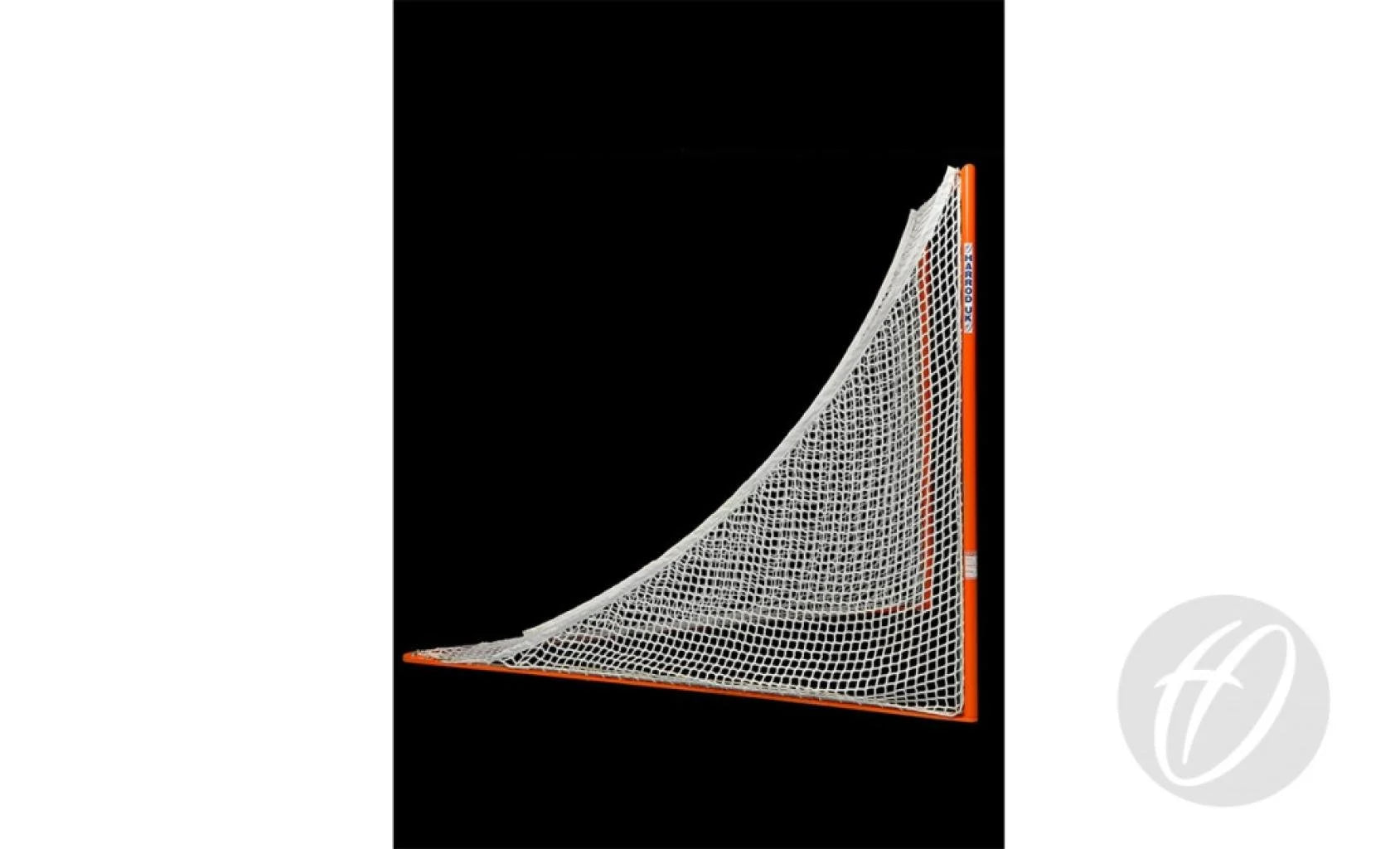 A white net is secured to an orange frame, forming the distinct curved, triangular silhouette of the Harrod Sport Freestanding Competition Lacrosse Goal against a black backdrop—evoking the regulation goals used in FIL-sanctioned matches. A light gray circular Harrod Sport logo with a stylized letter appears in the lower right corner.