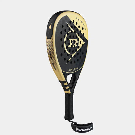 The Dunlop Aerostar Lite Padel Racket, featuring a gold and black design with a perforated face, Hyper Gryp finish, black handle, and branded wrist strap, is shown on a light gray background.