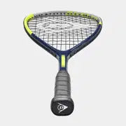 A Dunlop Tristorm Jr 25 Squash Racket with a black handle, blue and yellow frame, and black strings is displayed against a light gray background.