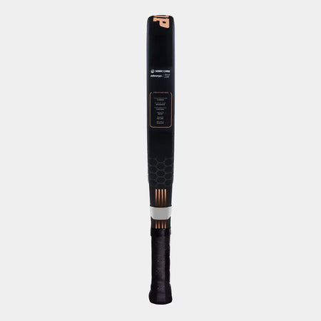 A Dunlop Galactica OS Lite Padel Racket, featuring a black and gold design, stands vertically against a plain light grey background. The racket displays extra grip on the handle and a honeycomb pattern near the base.