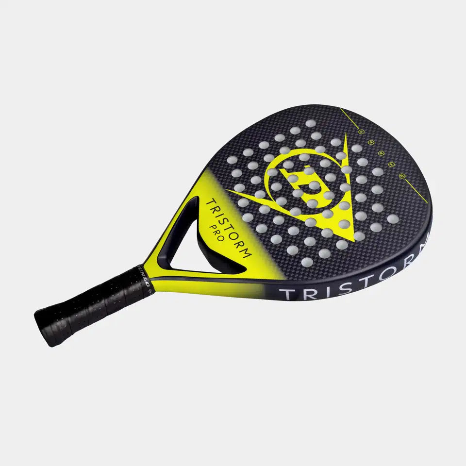 The Dunlop Tristorm Pro Padel Racket features a black and yellow design, perforated face, Power Frame technology, graphite construction, large triangular logo on the front, and "TRISTORM" text along the rim.