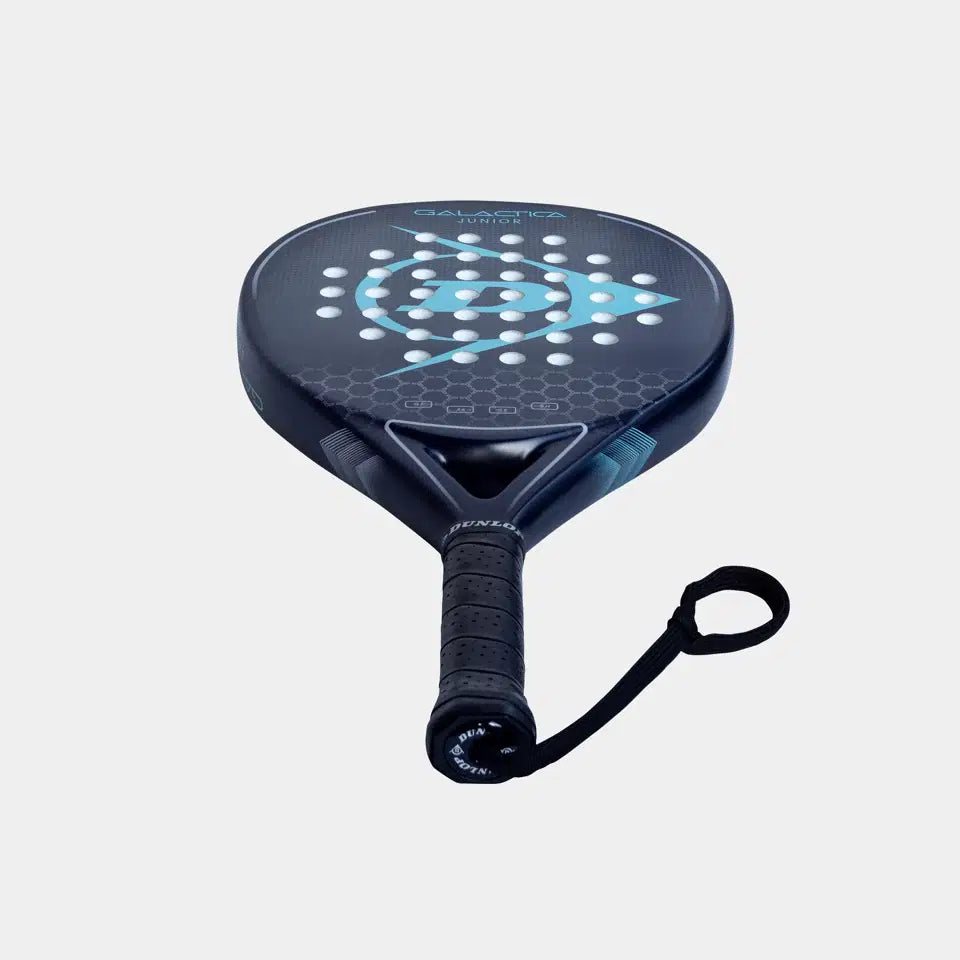 The Dunlop Galatica Junior Padel Racket by Dunlop features a graphite frame, black design with blue geometric pattern, perforated holes, and a secure black grip with wrist strap, shown against a light gray background.