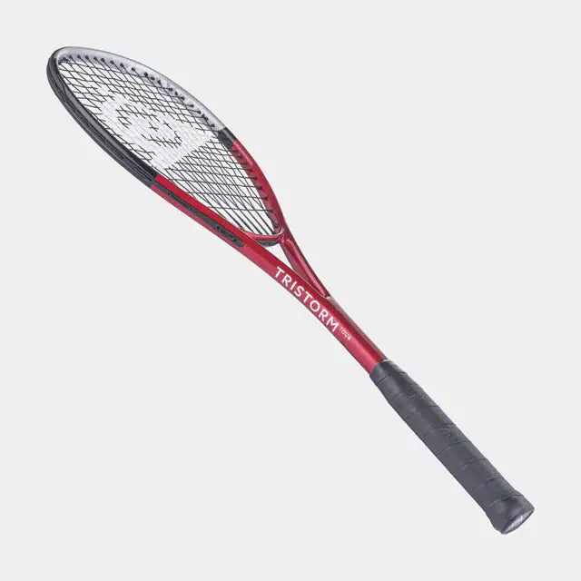 The Dunlop Tristorm Tour Squash Racket features a red and black design with a black grip and white strings, isolated on a light grey background—perfect for beginner players.