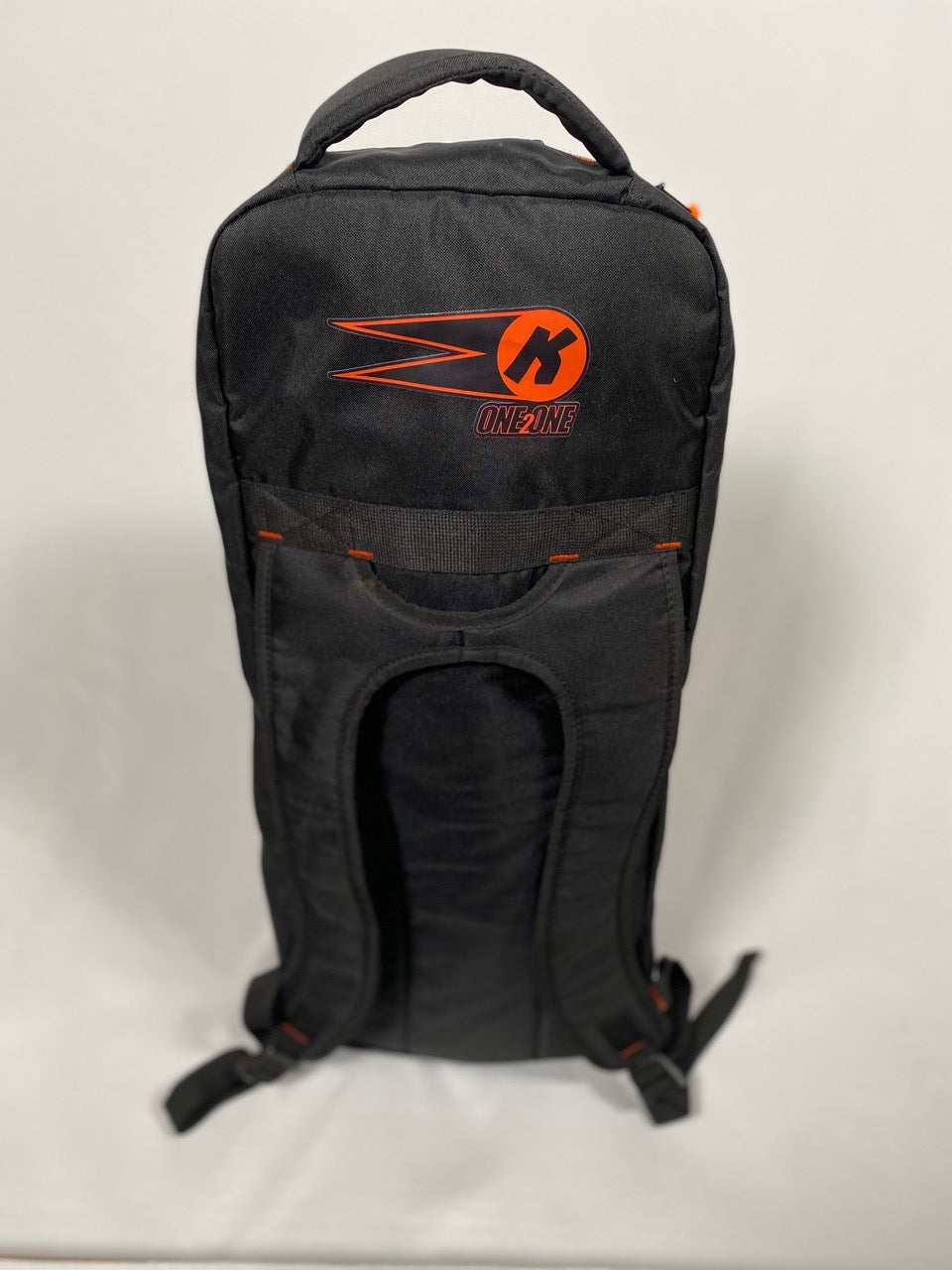 The Katchet KoachSak One2One is a black cricket coach bag with orange accents and a stylized K logo plus "ONLINE" on the front, shown upright on a plain white background. Ideal for carrying cricket equipment to one-to-one coaching sessions.