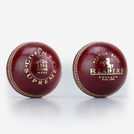 Two red leather Readers County Supreme A cricket balls, each with white hand stitching and gold embossed text and logos reading "Readers, Teston Kent, England, Estd. 1808.