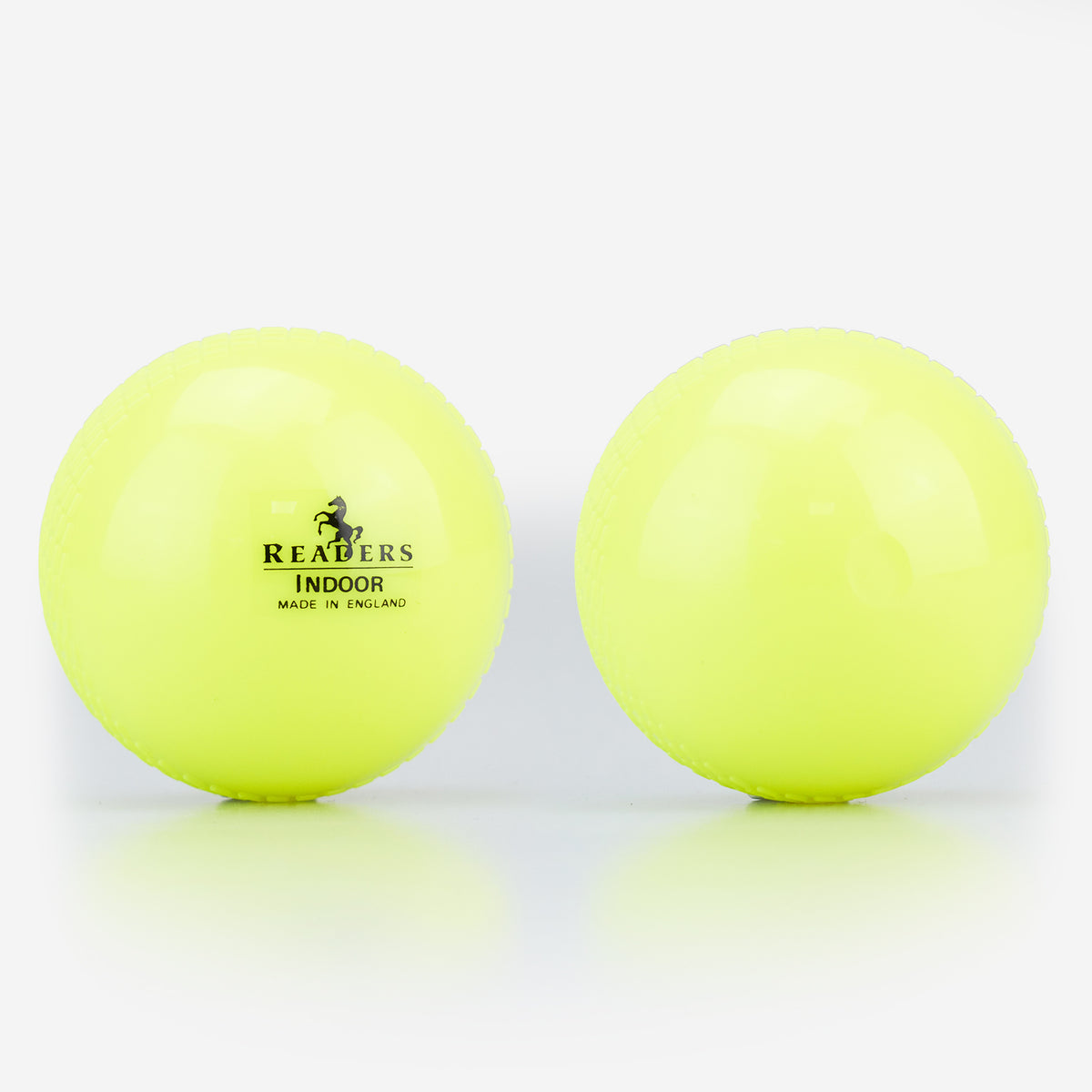 Two yellow Readers Indoor 4oz Cricket Balls are side by side on a white surface. The left ball shows the Readers logo, highlighting it as a lightweight plastic option from Readers for coaching or indoor cricket play.