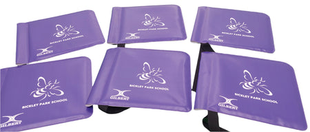 Six purple seat cushions with black straps are arranged on a white background. Each cushion features a white bee graphic and “BICKLEY PARK SCHOOL” beside the Gilbert logo, resembling Custom Printed Moon Flags by Martin Berrill Sports.