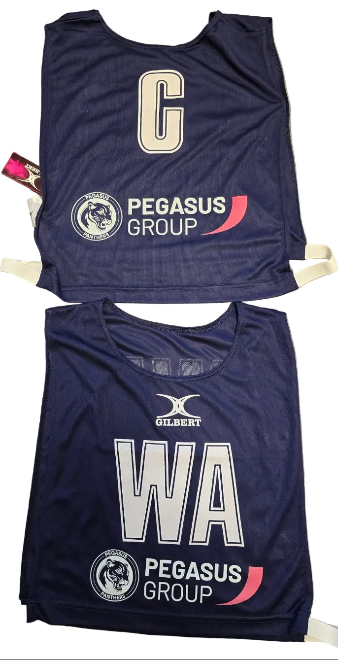 Two navy blue Personalised Gilbert Netball Bibs (Single Bibs) by Gilbert, each with white letters (“C” and “WA”), featuring the Pegasus Group logo and team crest.