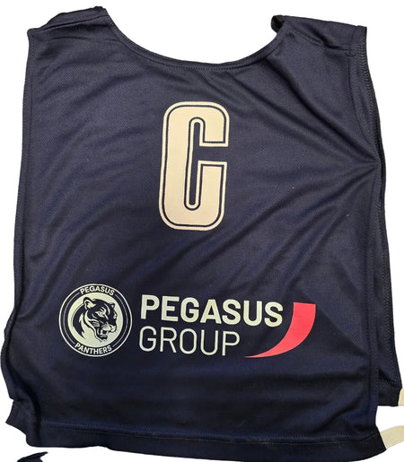 A Personalised Gilbert Netball Bib in navy blue by Gilbert, featuring a large white "C", the Pegasus Panthers panther head logo, and "PEGASUS GROUP" with a red curved graphic below.