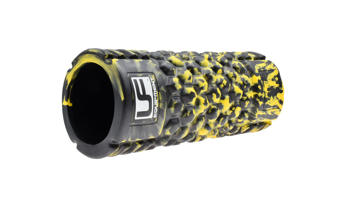 The Urban Fitness Massage Roller 33 x 14cm by Urban Fitness, in black with a textured surface and yellow paint splatters plus a side logo, is ideal for muscle recovery and shown on a white background.
