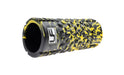 The Urban Fitness Massage Roller 33 x 14cm by Urban Fitness, in black with a textured surface and yellow paint splatters plus a side logo, is ideal for muscle recovery and shown on a white background.