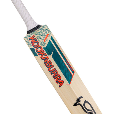 A close-up of the Kookaburra Nickel Pro Players Edition Junior Cricket Bat 2026, showcasing its white handle grip, Grade 1 English willow blade, bold red KOOKABURRA branding, and blue-green geometric patterns.