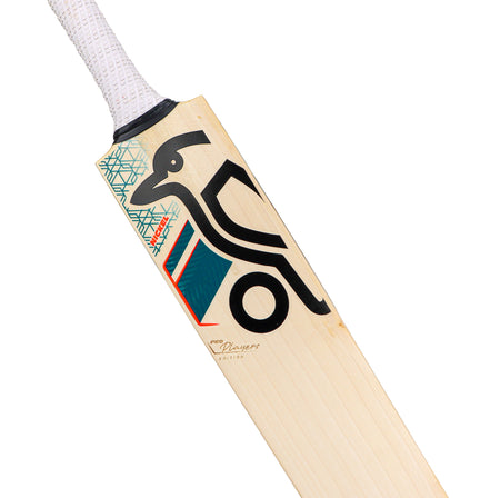A close-up of the Kookaburra Nickel Pro Players Edition Junior Cricket Bat 2026, featuring a white handle, bold black and teal graphics, a stylized bird logo, and geometric patterns on its Grade 1 English willow blade.