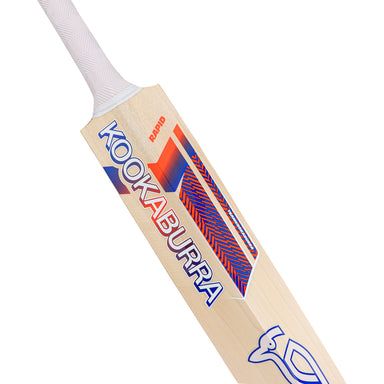A close-up of the Kookaburra Rapid Pro 2.1 Elite Cricket Bat 2026, featuring the Kookaburra branding and vibrant blue and red geometric designs on the blade with a partial view of its white grip handle.