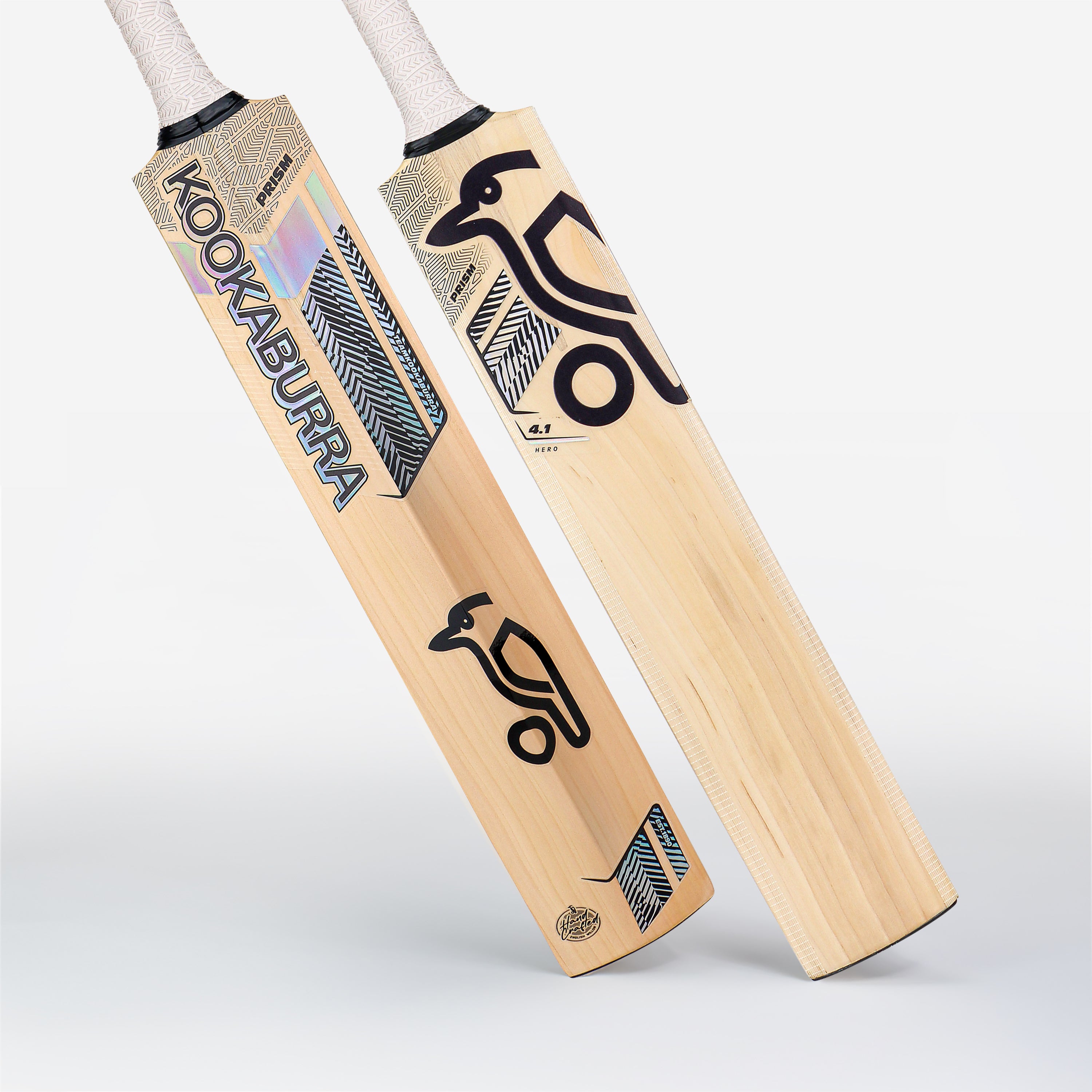 Two Kookaburra Prism 4.1 Hero Junior Cricket Bat 2026 models stand upright, showing the front and back. Both feature Kookaburra branding with blue, black, and holographic designs on light wood.