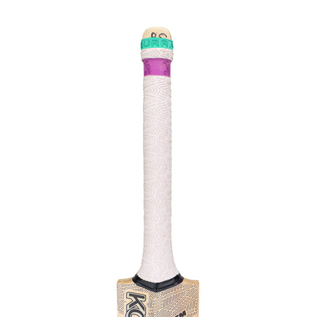A close-up of the Kookaburra Prism 6.3 Select Cricket Bat 2026 handle, wrapped in a white textured grip with a purple and green band, shows part of the Grade 5 English willow youth bat by Kookaburra visible at the bottom.