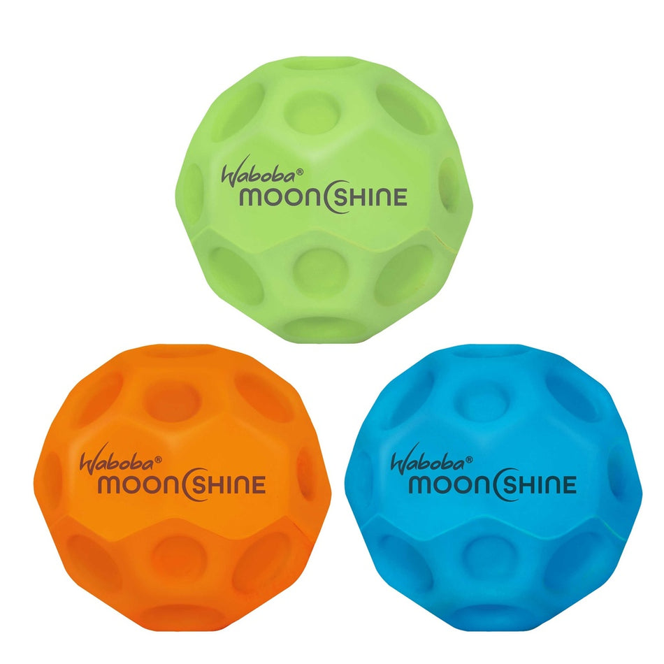 Three Waboba Moon Shine Balls in green, orange, and blue are arranged close together on a white background, ready for glowing hyper-bounce fun.