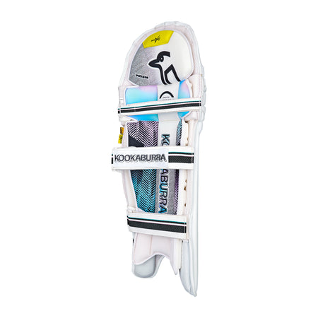 The Kookaburra Prism Pro Batting Pads 2026 are white with black straps, blue and pink accents, and Kookaburra logos on the shin and strap. Featuring Poron XRD protection, the front view highlights their detailed design.