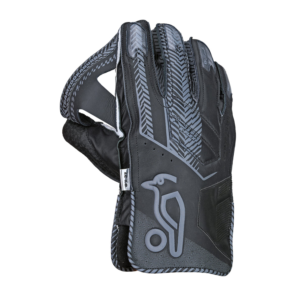The Kookaburra LC 1.0 Wicket Keeping Gloves 2026 by Kookaburra feature black and gray styling, a bird and ball logo, textured grip, and reinforced stitching—perfect for professional wicket keepers seeking durability.