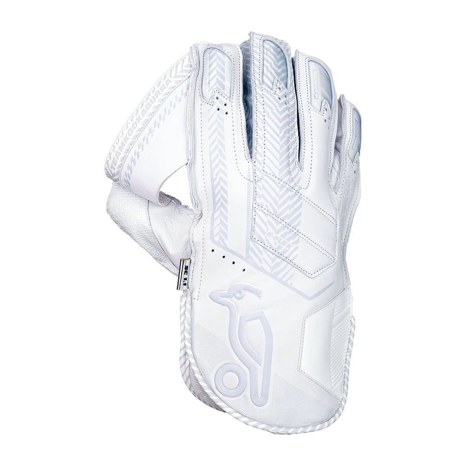 The Kookaburra SC 1.1 Wicket Keeping Gloves 2026 feature a white design with grey patterns, detailed stitching, and a stylized bird logo on the wristband, made from aniline sheep leather in a Shorti cut and shown angled to display the back and wrist.