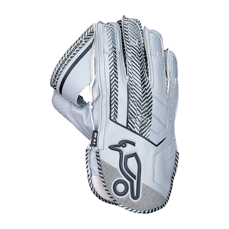 The Kookaburra SC 2.1 Wicket Keeping Glove 2026 features a white and gray design with black patterns, Velcro strap, octopus rubber grip, and a stylized bird logo on the back of the hand. Brand: Kookaburra.