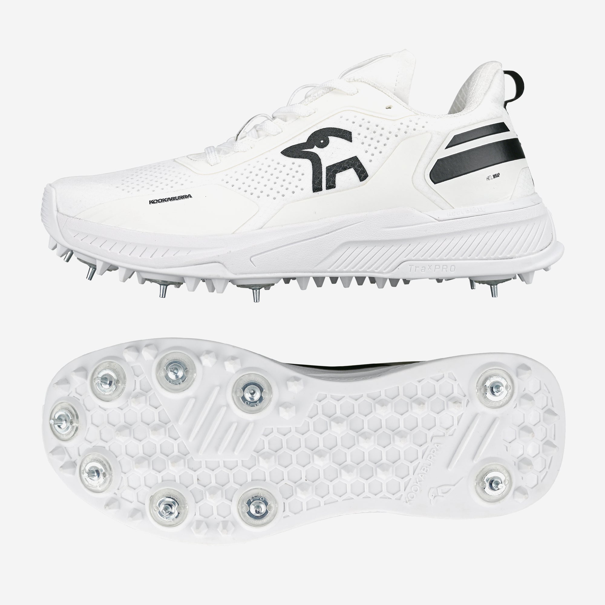 The Kookaburra KC Players Cricket Spikes are white shoes with black accents, a side logo, and a honeycomb-patterned sole featuring prominent metal spikes for grip. Shown from the side and bottom.