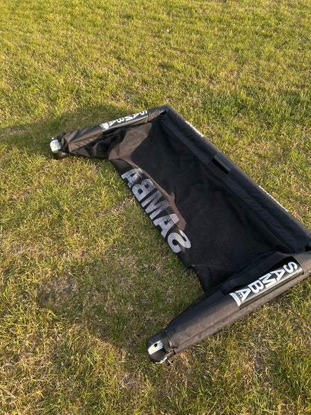A Samba Sports 4ft x 2.5ft Folding 3v3 Goal lies flat and collapsed on the grass, its net and frame visible, showing the portable goal not set up for play.