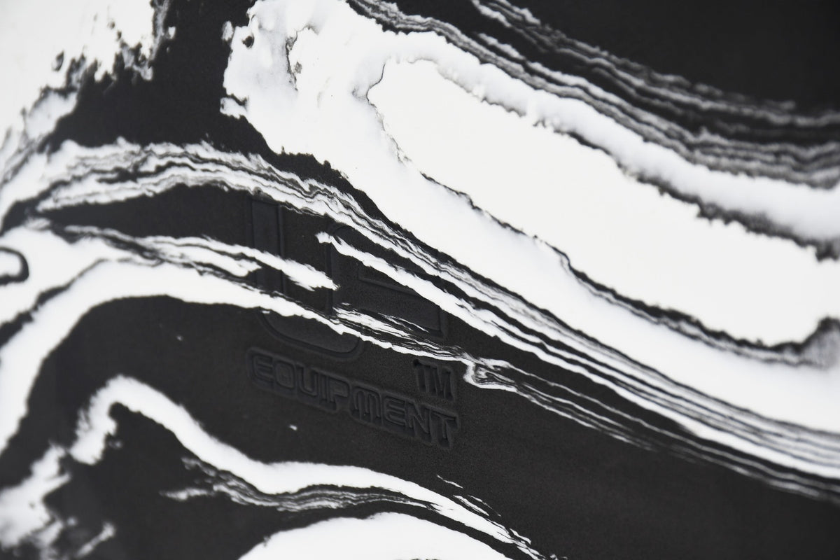 Close-up of the Urban Fitness Marbled Yoga Block, featuring white marbled wavy patterns on black and faintly embossed Urban Fitness branding.