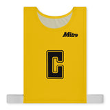 The Mitre Pro Netball Bib set features yellow bibs made from durable polyester micro mesh with a large black "C" outlined in yellow at the center, the "Mitre" brand name in black at the top right, and white elastic straps at the bottom.