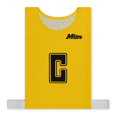 The Mitre Pro Netball Bib set features yellow bibs made from durable polyester micro mesh with a large black "C" outlined in yellow at the center, the "Mitre" brand name in black at the top right, and white elastic straps at the bottom.