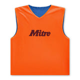 The Mitre Reversible Training Bib by Mitre is orange with a blue inner lining, sleeveless and cropped, featuring a V-neck and "Mitre" printed in black on the front.