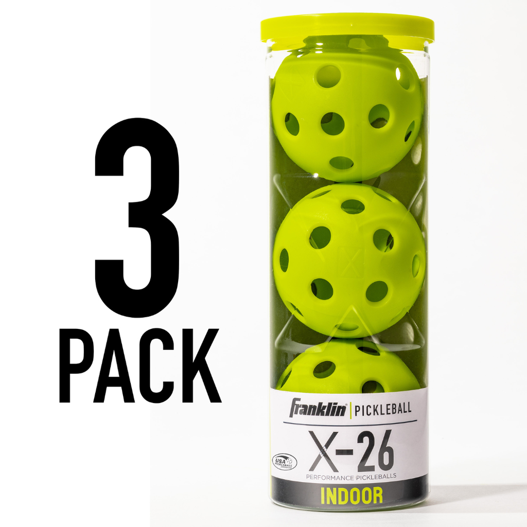 A clear plastic container holds three lime Franklin Indoor X-26 Pickleball balls stacked vertically. The label shows 3 PACK. Perfect for indoor play, these Franklin balls are USA Pickleball approved.