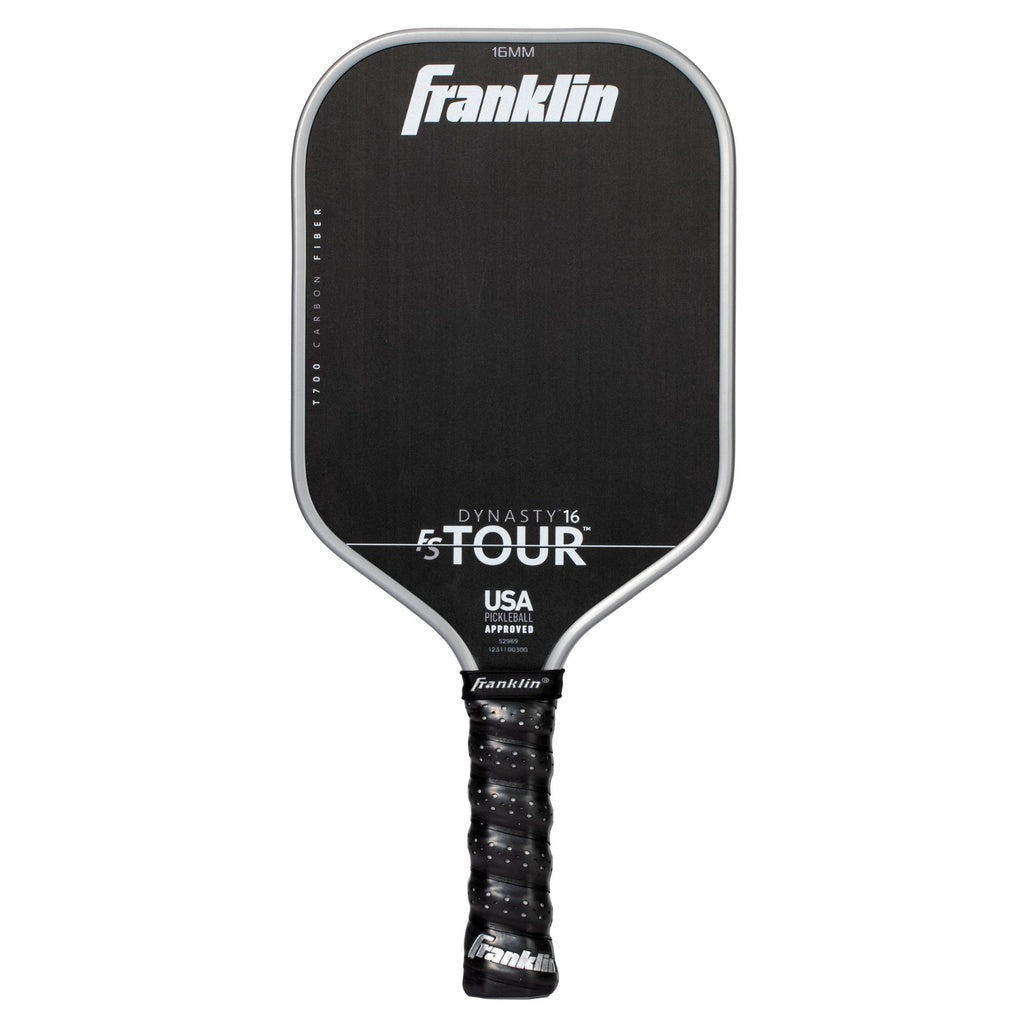 A grey Franklin FS Tour Dynasty Pickleball Paddle features a cushioned grip and white text showing the brand, model details, and USA Pickleball approved status on its carbon fiber face.