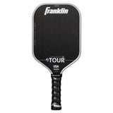 A grey Franklin FS Tour Dynasty Pickleball Paddle features a cushioned grip and white text showing the brand, model details, and USA Pickleball approved status on its carbon fiber face.