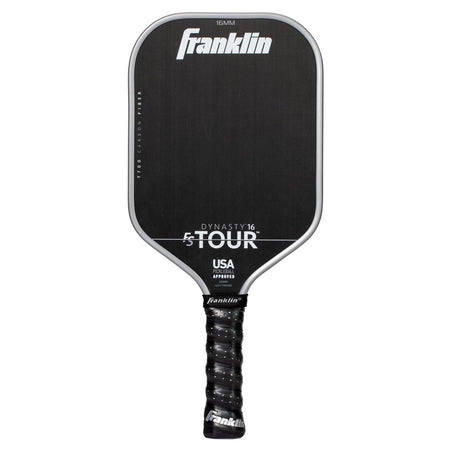 A grey Franklin FS Tour Dynasty Pickleball Paddle features a cushioned grip and white text showing the brand, model details, and USA Pickleball approved status on its carbon fiber face.