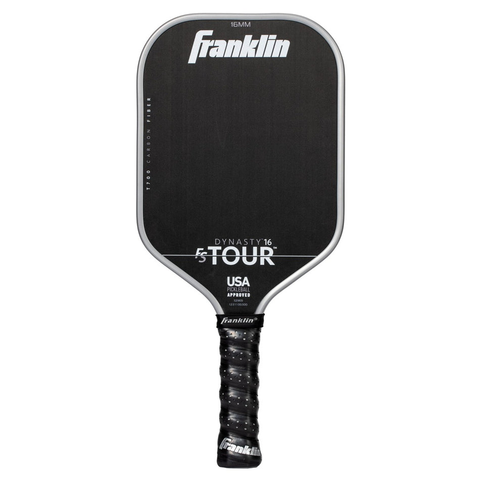 A grey Franklin FS Tour Dynasty Pickleball Paddle features a cushioned grip and white text showing the brand, model details, and USA Pickleball approved status on its carbon fiber face.