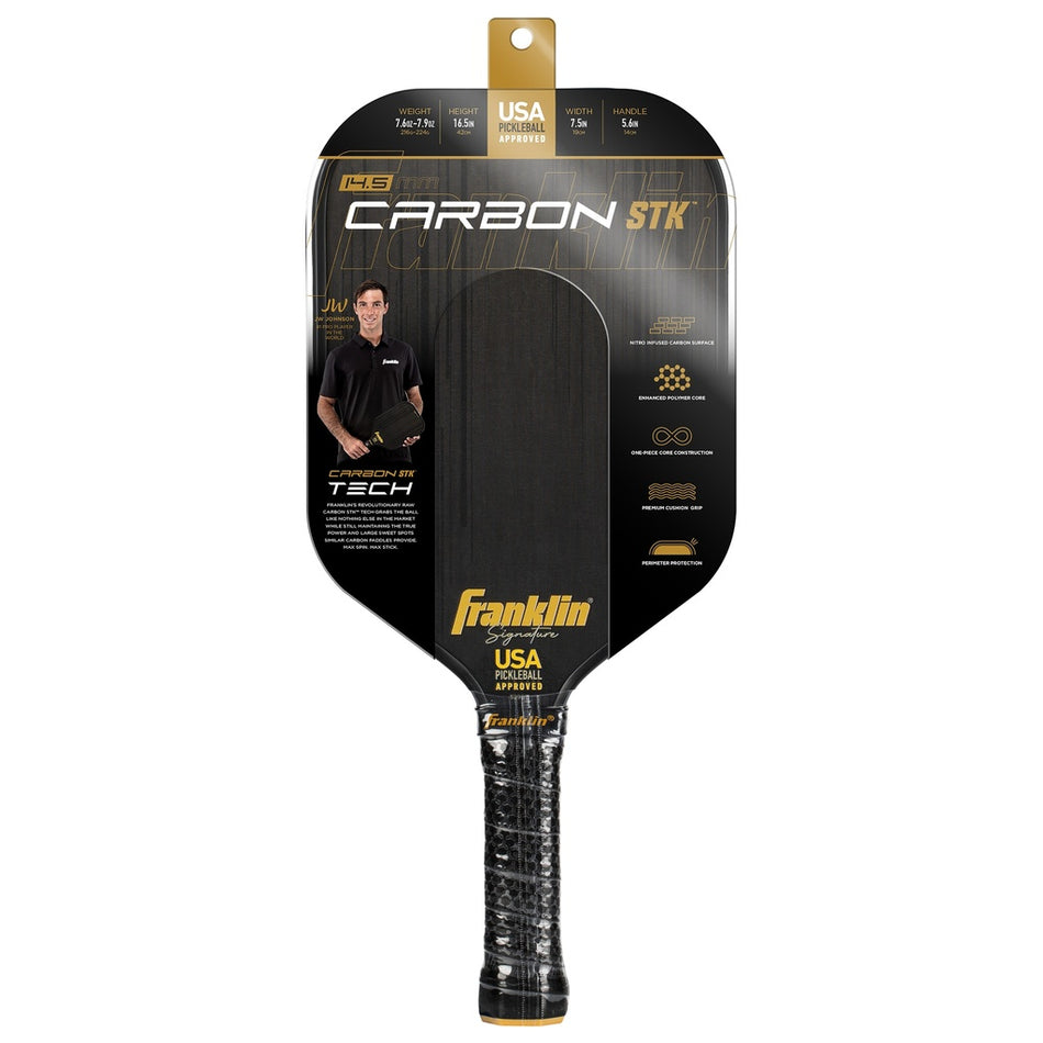 The Franklin Carbon STK Pickleball Paddle by Franklin comes in black packaging with a photo of a man holding the USAPA-approved paddle. Packaging highlights carbon fiber technology and key features.