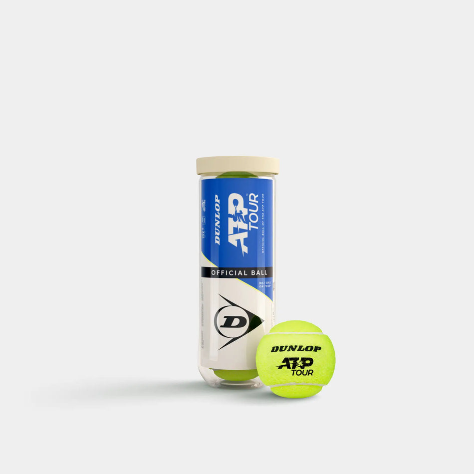 A Dunlop ATP Tour (3 Ball Tube) stands upright, featuring blue and white branding. In front, a yellow Dunlop tennis ball rests against a plain white background, emphasizing professional tour-level performance.