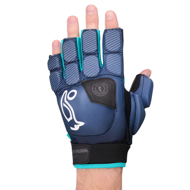 A close-up of a hand wearing the Kookaburra Spirit Plus Hockey Handguard by Kookaburra, a blue and black glove with turquoise trim, HDF finger insert for protection and grip, and white logo, shown against a white background.