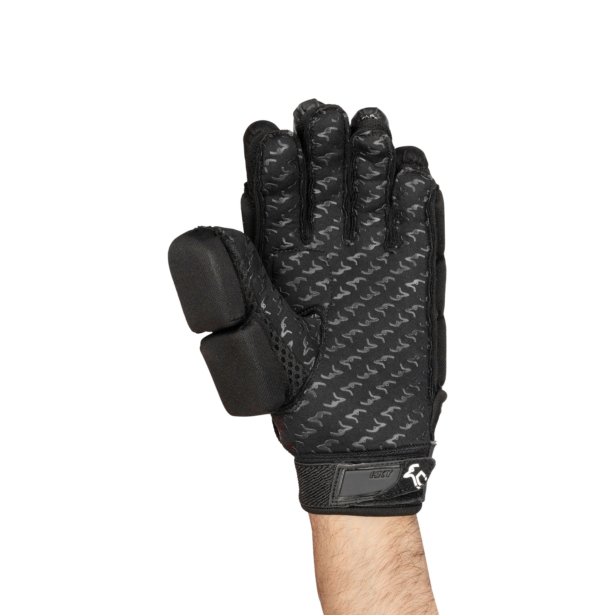 A person wearing a Kookaburra Rebuke Hockey Glove by Kookaburra with reinforced padding on the index and middle fingers, a subtle patterned design, and Velcro wrist strap holds their hand upright against a white background.