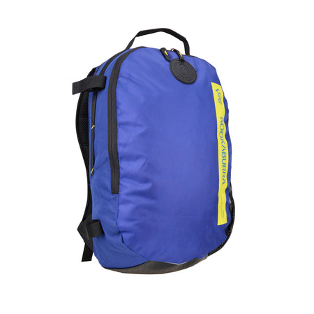 The Kookaburra Apollo Hockey Rucksack 2025 is a blue backpack with black adjustable shoulder straps, a black top handle, a yellow vertical accent with text, and a round black logo patch near the top for a modern look.